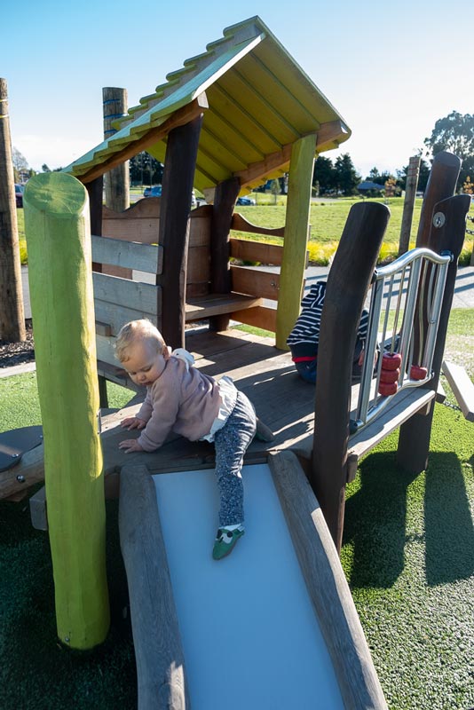 Emilia from Backyard Travel Family tests out the slide in the toddlers area of the Foster Park Playground, Rolleston, New Zealand