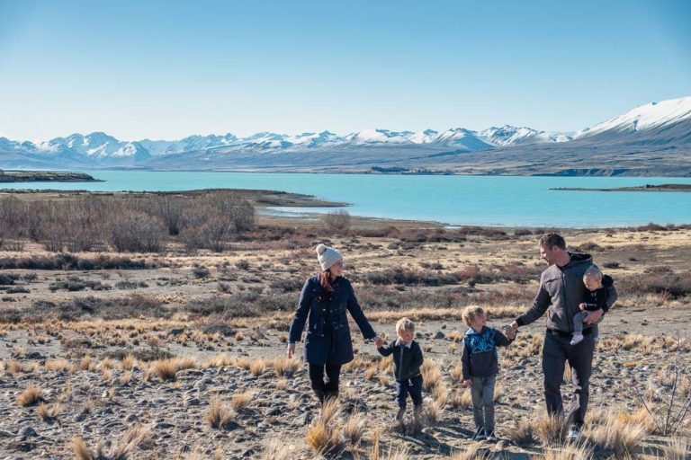 Backyard Travel Family walking hand in hand, checking out the many things to do in Lake Tekapo with kids in winter // Mackenzie Region, Canterbury, New Zealand