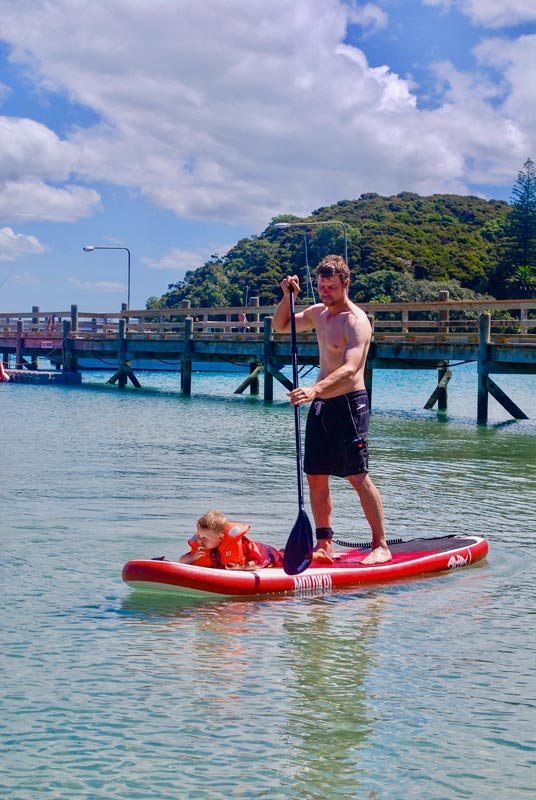 Ashley from Backyard Travel Family paddleboards in Otehei Bay on Urupukapuka Island in New Zealands Bay of Islands