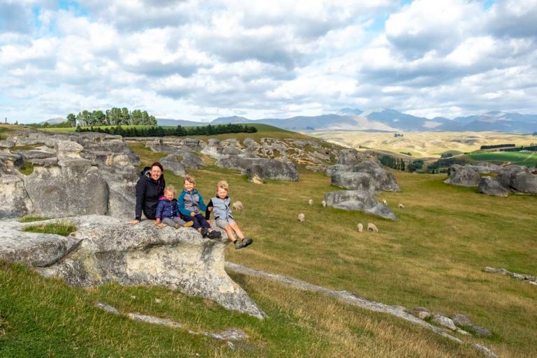 Backyard Travel Family sit on the strange rock formation of Elephant Rocks New Zealand, in the Waitaki Valley