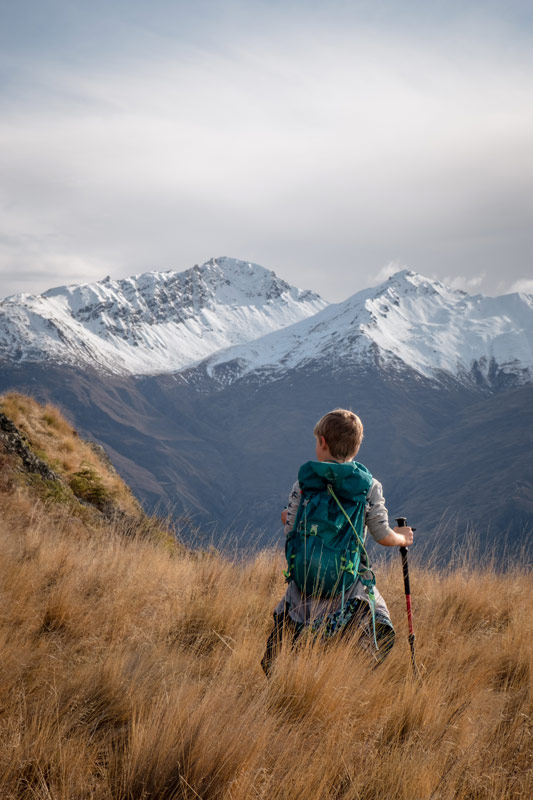 Nathan looks over the snow capped Southern Alps on the Rocky Mountain Wanaka hike