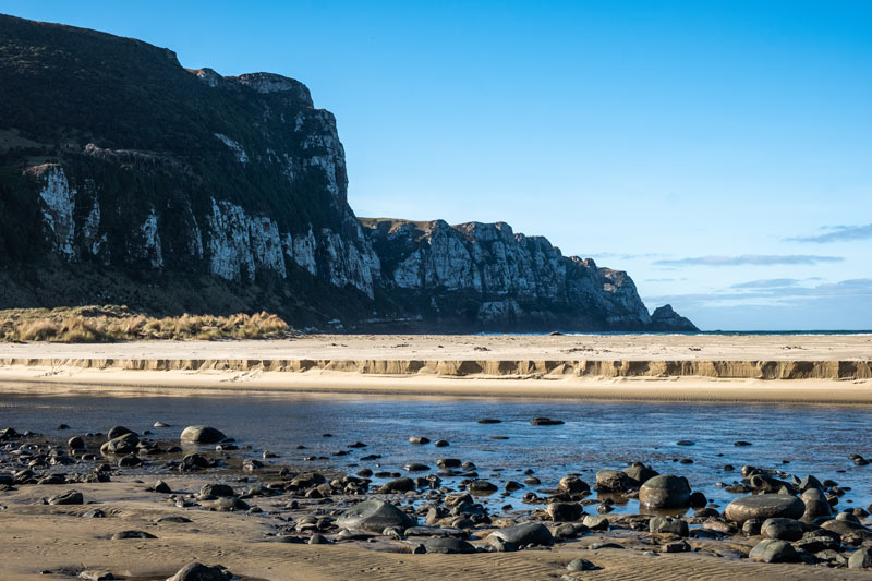 Purakaunui Bay is perhaps one of the most beautiful things to see in the Catlins NZ, with towering cliffs over the golden sand beaches