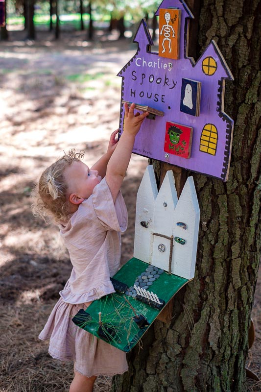 Emilia from Backyard Travel Family is exploring a Christchurch fairy door walk at Bottle Lake Forest