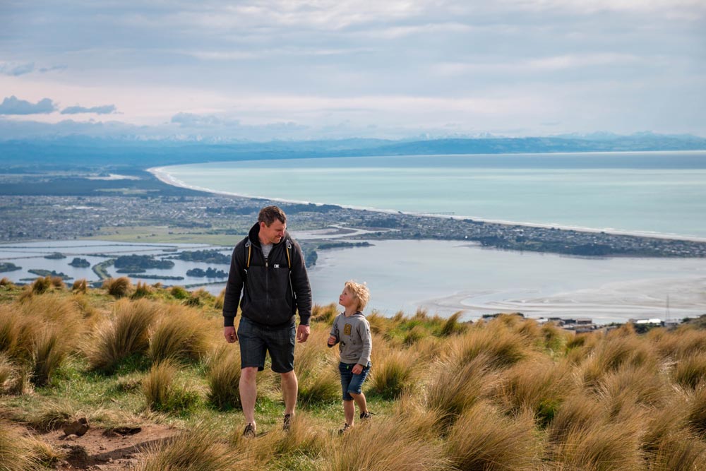 Father and son look at visit the Christchurch Gondola, with epic views overlooking the Canterbury Coastline, New Zealand