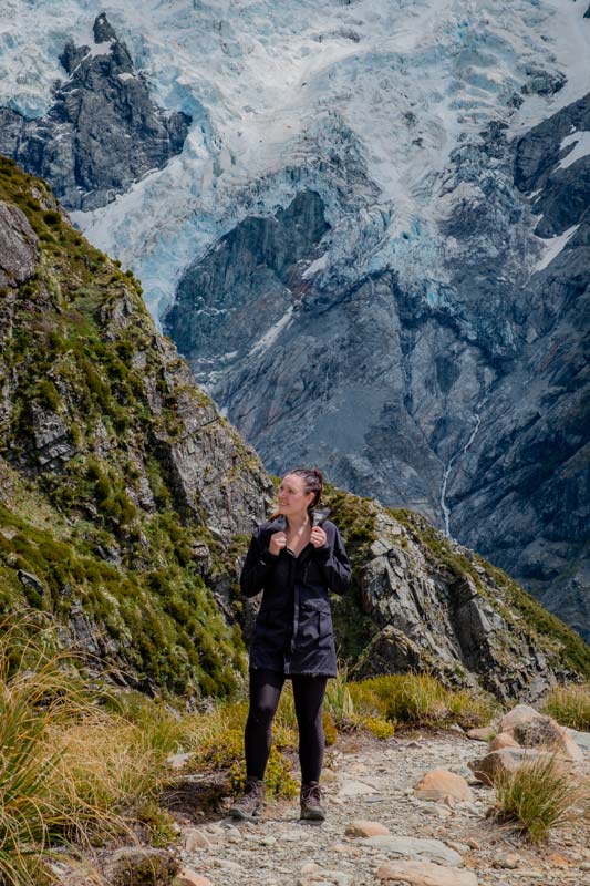 Jen looking at mountain views, standing in front of a glacier at the top of the Sealy Tarns Mt Cook Track
