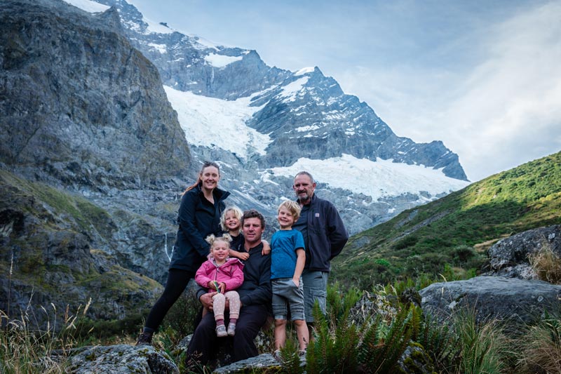 Backyard Travel Family and Grandad take a family photo in front of the Rob Roy Glacier near Wanaka, New Zealand
