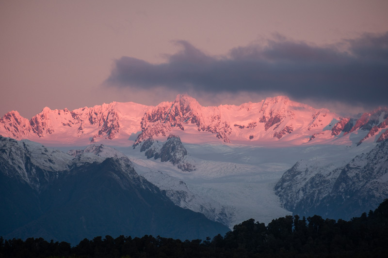 Pink hues of sunset on Mt Tasman and Mt Cook from Gillespies Beach on the West Coast