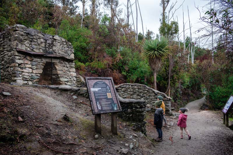 Backyard Travel Family children learn about the history of the limestone kilns on the Bobs Cove walk Queenstown
