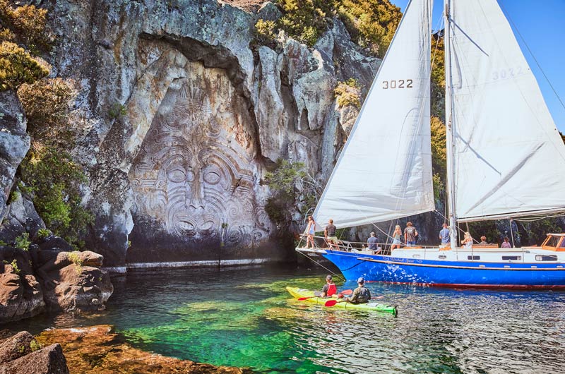 A sail boat visit the Maori Rock in Taupo, one of the best things to do in Taupo with kids