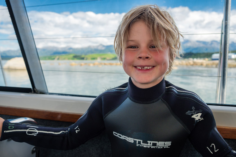 Nathan sits on the dolphin encounter boat, waiting to swim with dolphins, kaikoura, New zealand