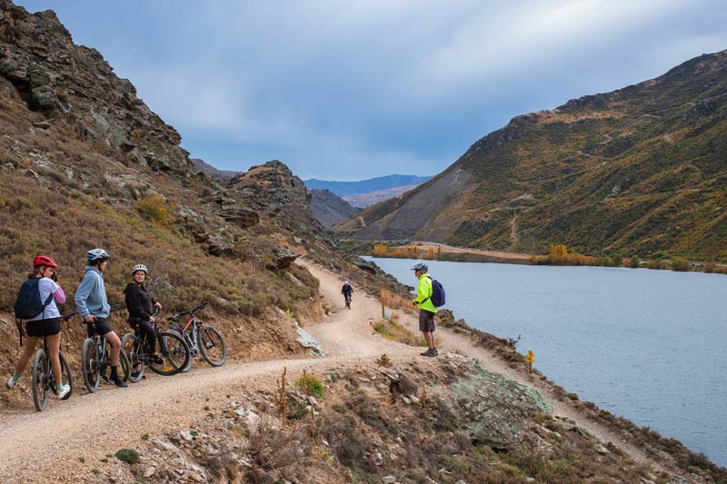 Bikers pull over on the Lake Dunstan Cycle Track to let riders pass on a narrow section on the trail
